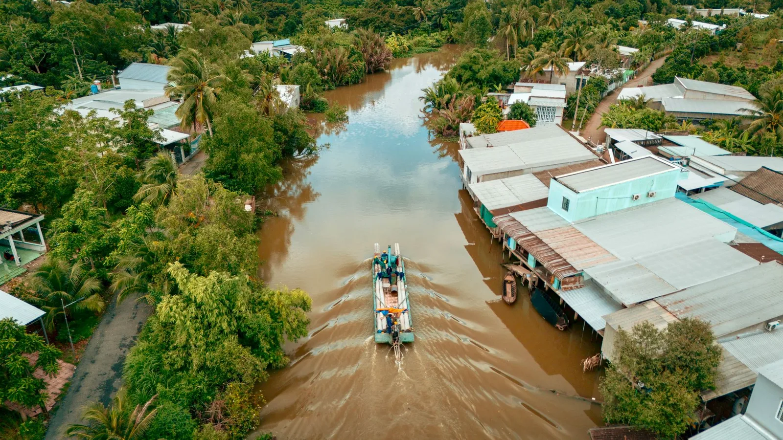 Con kênh và dãy nhà ven sông ở một làng miền Tây nhìn từ trên cao, minh họa đất của hộ gia đình sử dụng chung