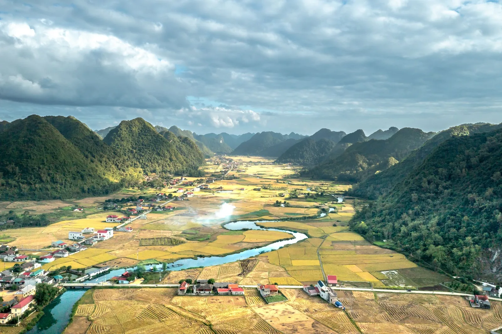 Thung lũng Bắc Sơn với ruộng lúa chín, dòng sông và nhà dân dọc đường nhìn từ trên cao, minh họa đất đai của nhiều gia đình trong một làng