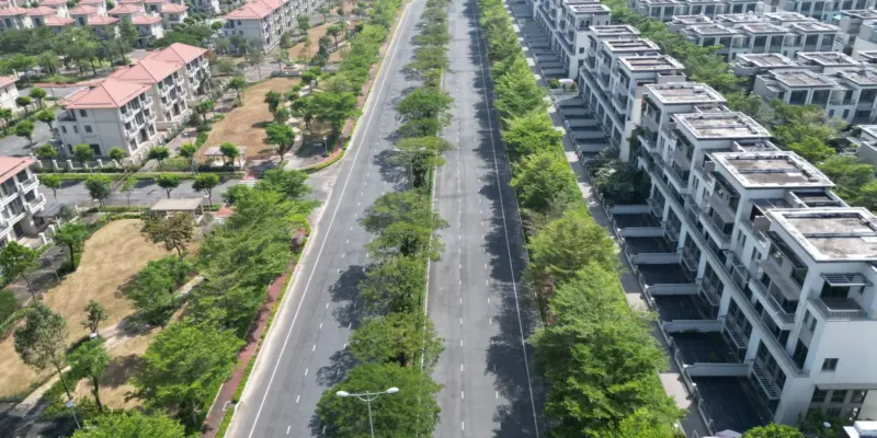 Khu dân cư mới ở Đồng Nai nhìn từ trên cao, các dãy nhà và lô đất xếp đều hai bên đường rợp cây, minh họa một khu đất ở được quy hoạch đồng bộ
