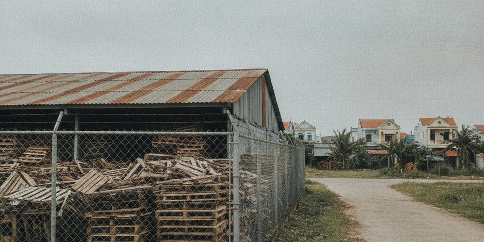 Ảnh một nhà kho mái tôn và bãi để hàng có hàng rào ở ven đô Việt Nam, minh họa kho bãi của tổ chức kinh tế không thuộc khu vực sản xuất, là một phần của đất thương mại dịch vụ