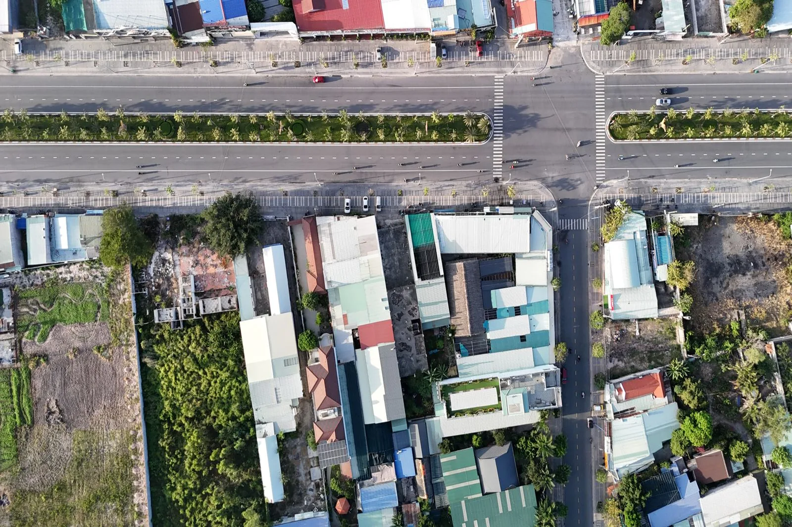 Ảnh chụp từ trên cao một nút giao ở Phú Mỹ, Việt Nam, dọc đường có nhà ống xen các lô đất trống, minh họa những lô đất thường được góp vốn mua chung