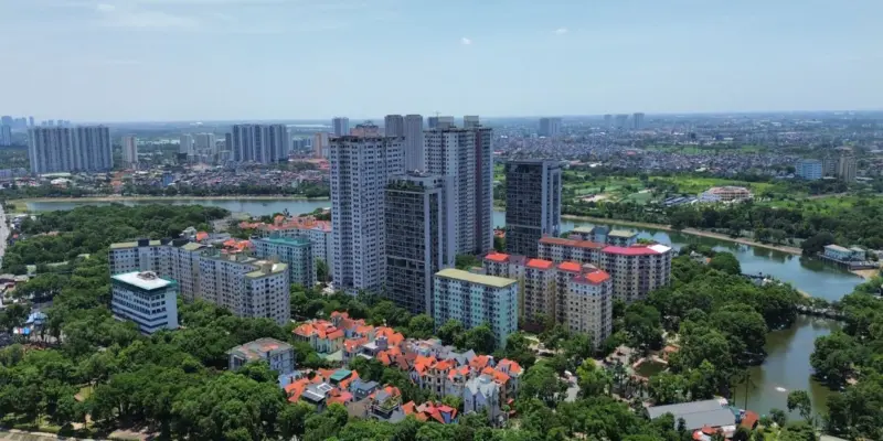 Khu đô thị ở Hà Nội nhìn từ trên cao, các tòa chung cư cao tầng đứng cạnh dãy biệt thự mái đỏ bên hồ, minh họa nhà ở thương mại gồm cả căn hộ và nhà ở riêng lẻ