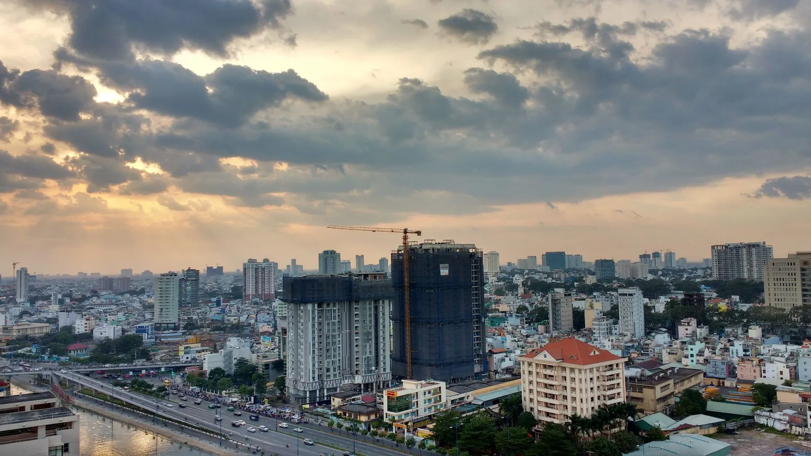 Đường chân trời TP. Hồ Chí Minh lúc hoàng hôn với tòa nhà đang xây và cần cẩu, minh họa dự án có thể bị điều chỉnh quy hoạch
