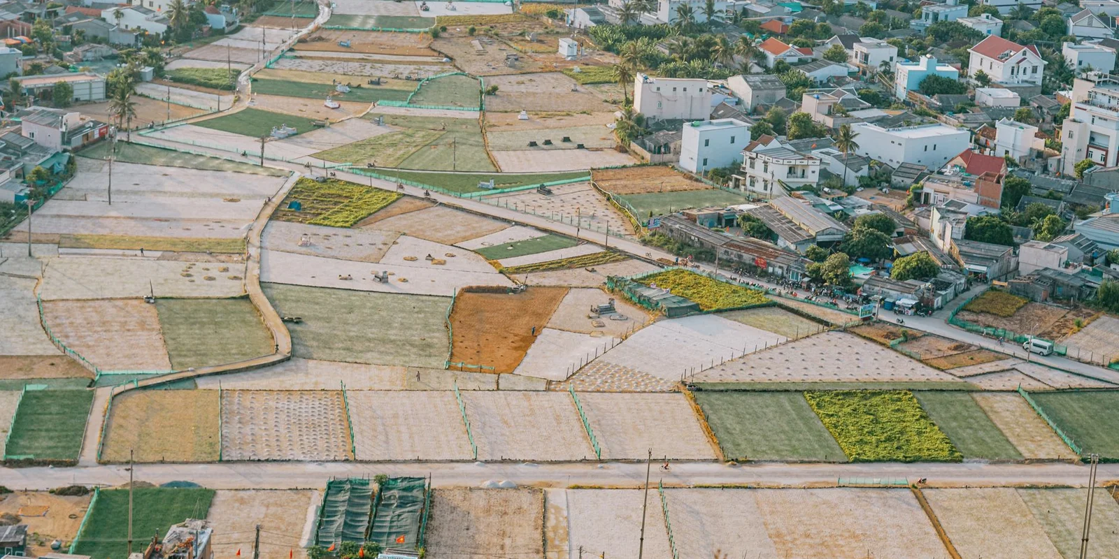 Ảnh chụp từ trên cao những ô ruộng và khu dân cư ở vùng quê Quảng Ngãi, minh họa đất nông nghiệp và đất ở của các hộ gia đình