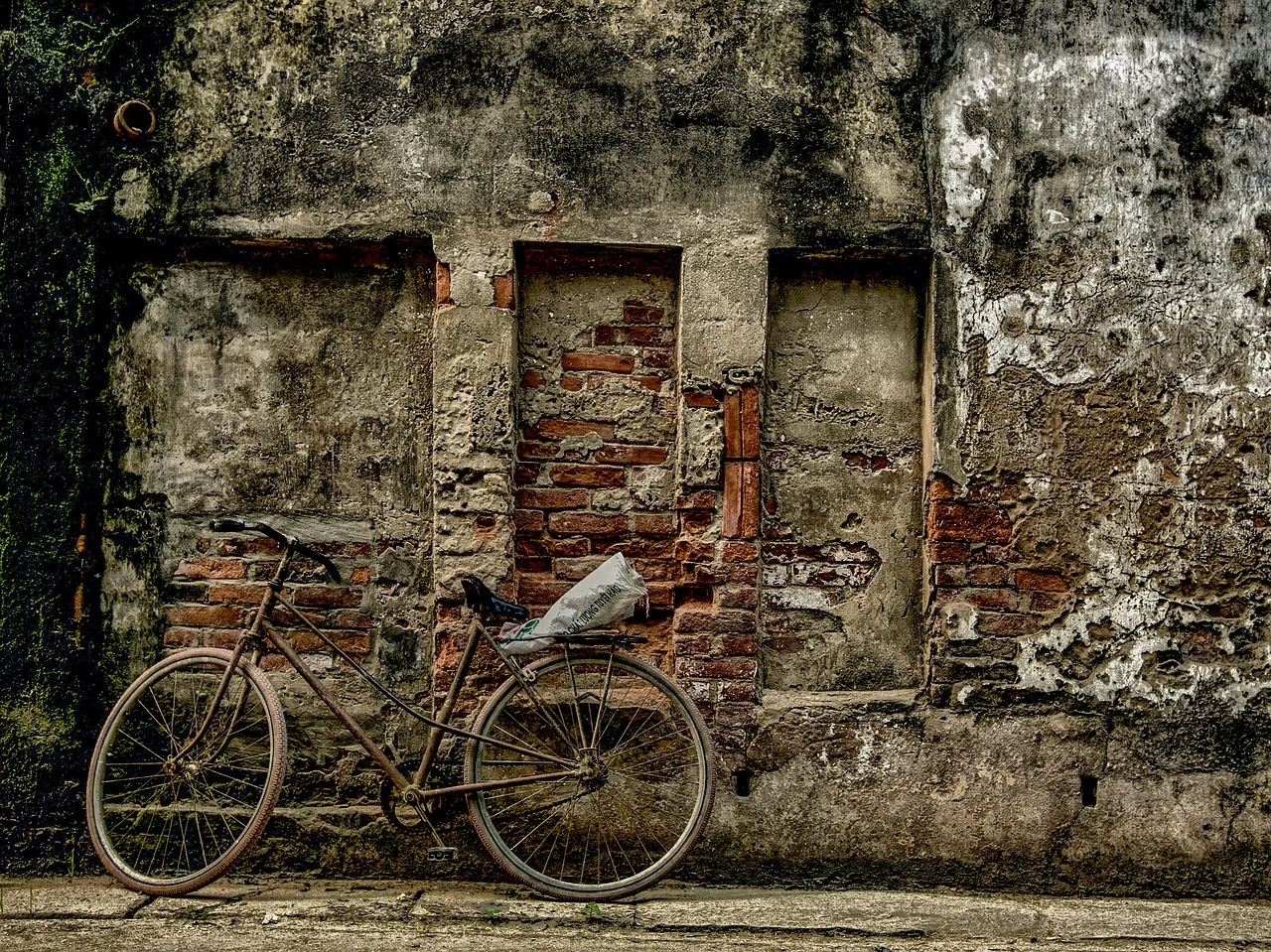Bức tường gạch cũ của một ngôi nhà ở Phú Xuyên, Hà Nội, với chiếc xe đạp dựng bên, minh họa căn nhà cũ của người đã mất lâu năm
